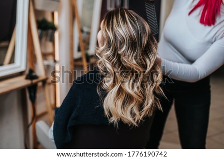 Beautiful hairstyle of young woman after dyeing hair and making highlights in hair salon. Royalty-Free Stock Photo #1776190742