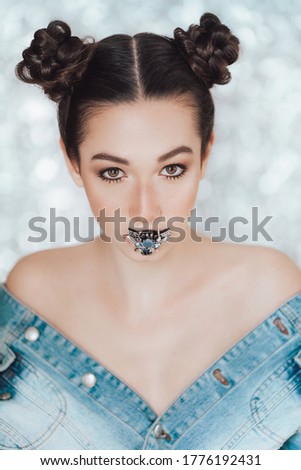 Portrait of beautiful young brunette girl holding a handmade cancer brooch. 
Fashion photo