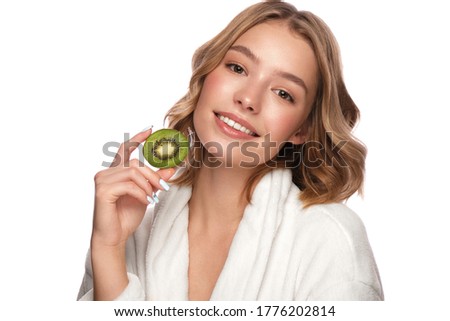 Beautiful tender young girl in a white coat with clean fresh skin posing in front of the camera. Beauty face. Skin care. Photo taken in studio on a white isolate background.