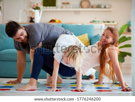 cheerful family having fun, playing twister game at home Royalty-Free Stock Photo #1776246200