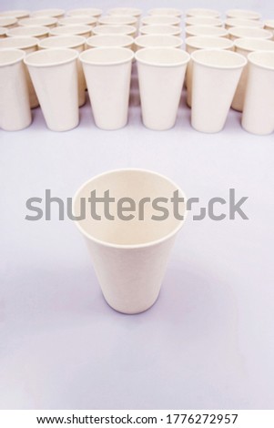 A group of paper cups with an isolated paper cup. Conceptual image