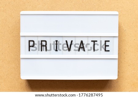 Lightbox with word private on wood background