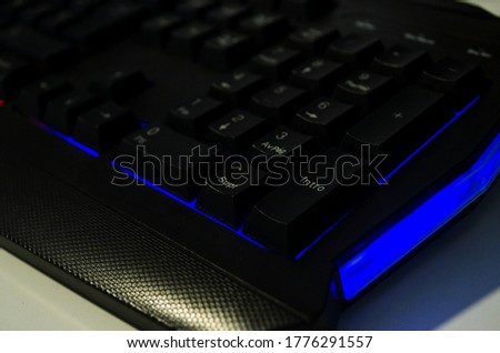 Black gaming keyboard close up with blue led backlit. Computer keyboard for work or play.