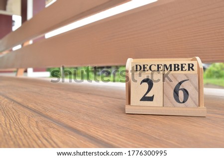 December 26, Number cube with wooden balcony background.