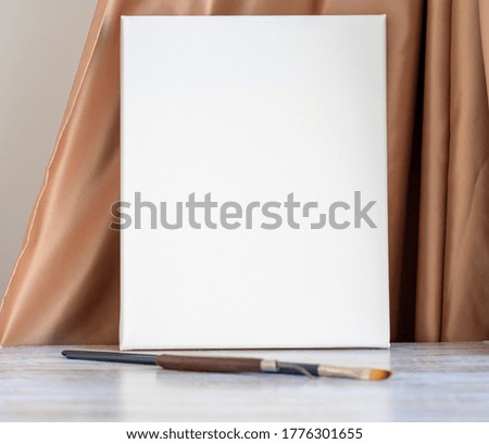 brushes and blank canvas on a wooden background. selective focus.
