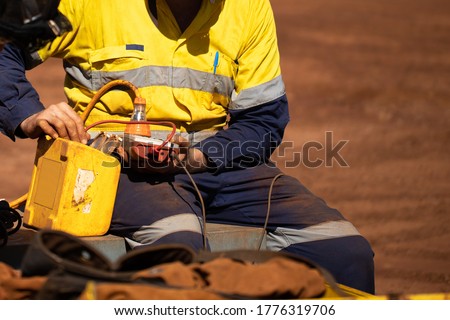 Safety workplace trained competent electrician setting holding electricity tester and conducting monthly safety testing tagging power residual-current device (RCD) prior use construction site Perth 