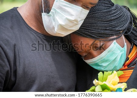 black people mourning lost ones to coronavirus, wearing face masks, showing support for each other Royalty-Free Stock Photo #1776390665