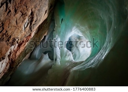 Ice Formations in a big ice cave “Eisriesenwelt“ in the austrian alps is a tourist attraction near Salzburg and Werfen with green reflections in the frozen waterfall underground and limestone rock