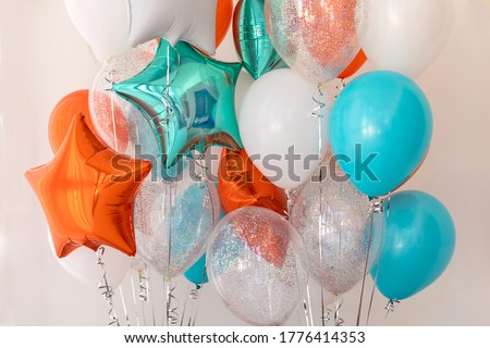Composition of blue, silver, orange and transparent balloons with helium. Foil balloon in the shape of a star. The concept of decorating a room with helium balloons for holidays or birthdays Royalty-Free Stock Photo #1776414353