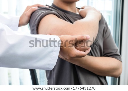 Female physiotherapists provide assistance to male patients with elbow injuries to examine patients in rehabilitation centers. Rehabilitation physiotherapy concept. Royalty-Free Stock Photo #1776431270