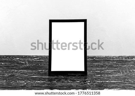 Wooden floor over concrete or decorative plaster wall and black photo frame with copy space for a text background. Mock up for design.