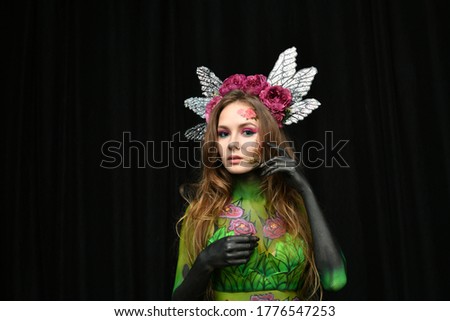 beautiful girl in peony flower costume posing on black background