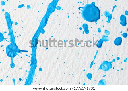 Blue paint splashes on white canvas as background. Art and creativity
