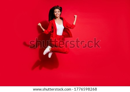 Full length photo of attractive lady worker having fun jumping high up good mood celebrate startup success wear blazer suit pants footwear isolated bright red color background