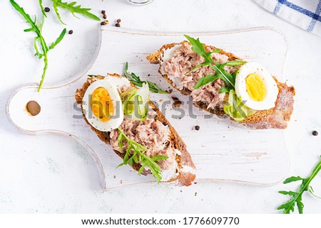 Toasts with tuna. Italian bruschetta sandwiches with canned tuna, egg and cucumber. Top view, flat lay, copy space Royalty-Free Stock Photo #1776609770
