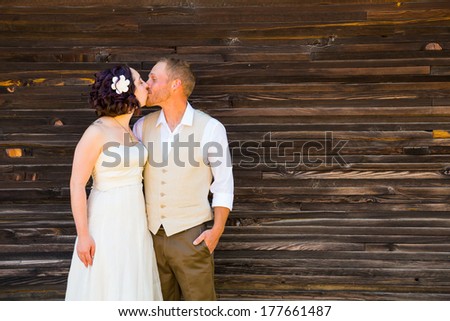 Copyspace on a wood texture wall with the bride and groom sharing a moment on their wedding day.