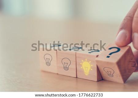 creative idea concept. hand man flip wooden block cube form Question mark symbol to right light bulb symbol. vintage style