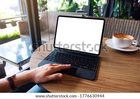 Mockup image of a woman using and touching on tablet touchpad with blank white desktop screen as a computer pc on the table