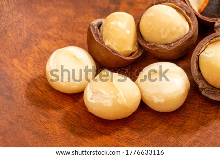 Macadamia nuts and shells on wooden board