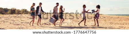 Picture of amazing young group of friends walking outdoors on the beach.