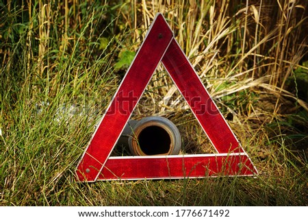 Warning triangle in front of a water pipe      