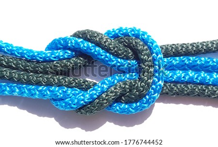 green and blue rope knot isolated on a white background as a strong nautical marine line tied together as a symbol for trust and faith ,Selective focus
