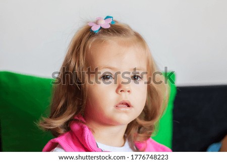 portrait of child with haircut and pink vest, note shallow depth of field