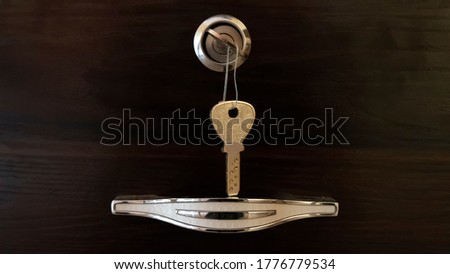 close view of chrome handle with key lock isolated on wooden background