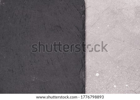 Black square slate on a light gray concrete background. Free space for text