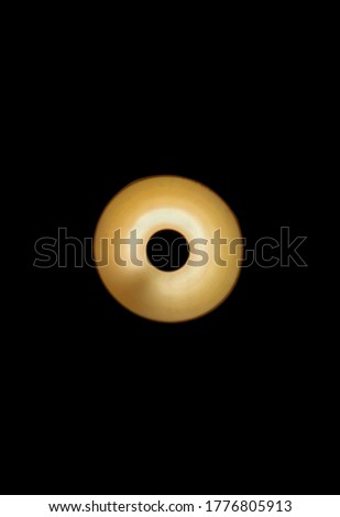 A Round shaped Yellow colored led light with black background.