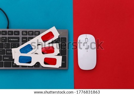 PC keyboard with 3d glasses on red blue background. Entertainment. Top view