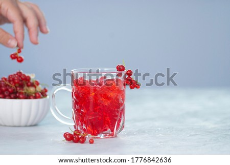 Red currant jam on the light gray background. Summer natural tasty jam fruits berries red beautiful picture with copy space. Juicy sweet food.