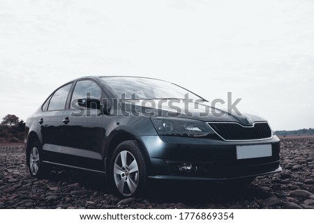 black sedan sport car on rocky river road. Royalty-Free Stock Photo #1776869354