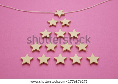 Many wooden little stars on a pink background