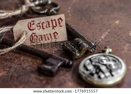 two old keys on a rusty metal table with labels : escape game Royalty-Free Stock Photo #1776915557