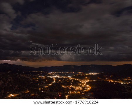 City night sky looking over Estes Park Colorado with beautiful night sky and thunder and lightning storm over mountain range