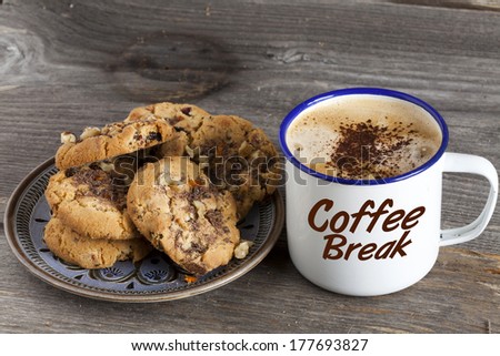 Plate of cookies and a pot of coffee with the word "Coffee Break" on a rustic wooden board