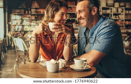 Couple having coffee at a coffee shop. Man and woman meeting at cafe. Royalty-Free Stock Photo #1776940622