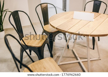 Wooden table and chair in cafe. Modern oak furniture. Place for text. Cafe decor. 
