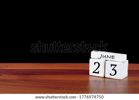23 June calendar month. 23 days of the month. Reflected calendar on wooden floor with black background
