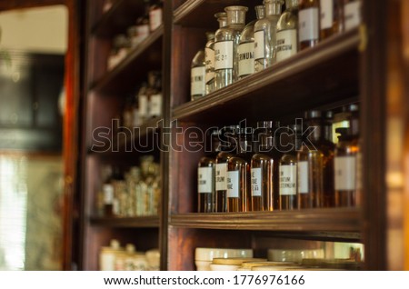 Ancient pharmacy, jars with medicines, transparent brown glass with inscriptions, medicine, health, sale of drugs, wooden shelves Royalty-Free Stock Photo #1776976166