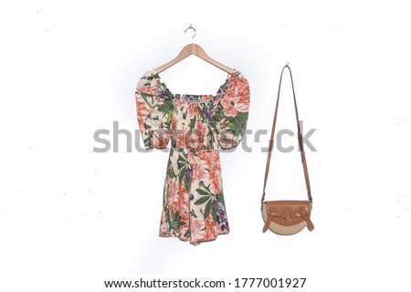 Fashion dress with floral ,leaf, plants pattern with leather handbag on hanging


