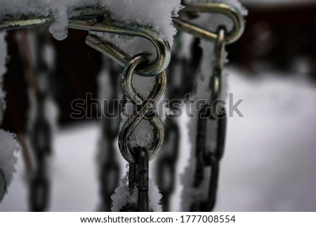 This picture shows a chain in the middle of the winter during a snow storm.