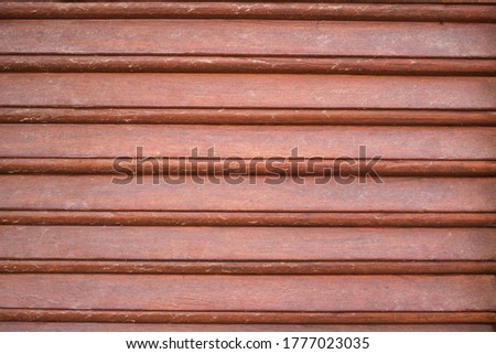 This unique photo shows a wooden shutter on a door. you can see the brown wooden ribs and texture very well.
