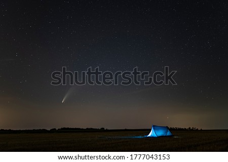 C / 2020 F3 comet (NEOWISE) in the evening sky. Camping under the starry sky, where there is a bright comet and a tail between the stars. Photographed in Hungary on July 14, 2020.