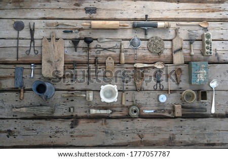 
NOSTALGIC PICTURE OF OLD COOKWARE OR KITCHEN UTENSILS ORDERED ON A WOODEN TABLE TOP VIEW.