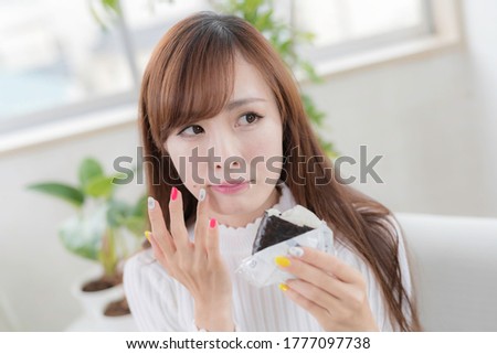 
Female office worker eating rice balls at the desk during lunch break