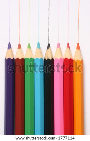 Large colored pencils with pencil marks on white paper