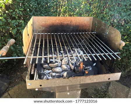 Empty BBQ Hot Fire Grill And Burning Charcoal Briquettes. Outdoor Scene.