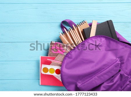 Stationery and briefcase on a blue wooden background, top view